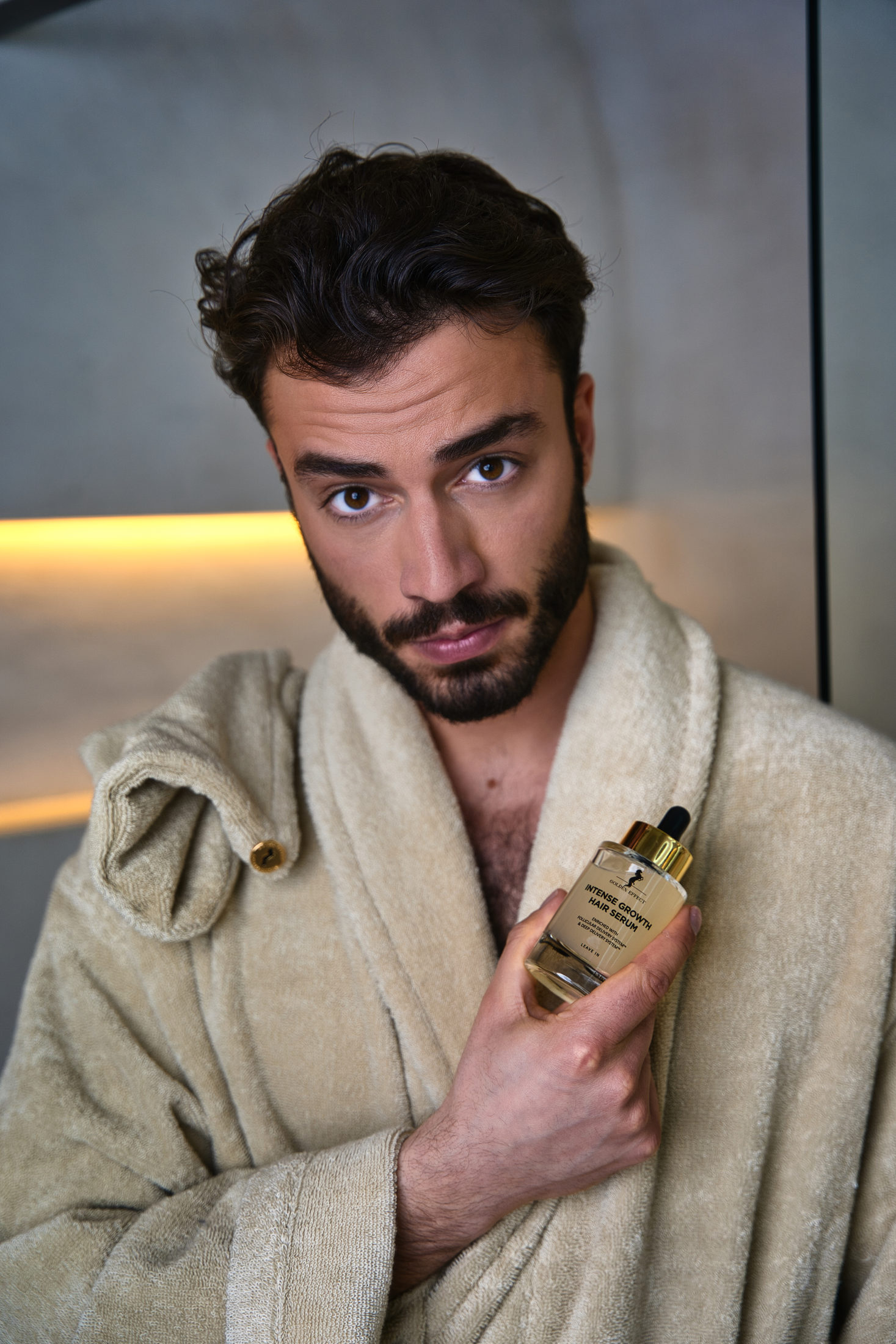 Male model holding Golden Effect hair serum
